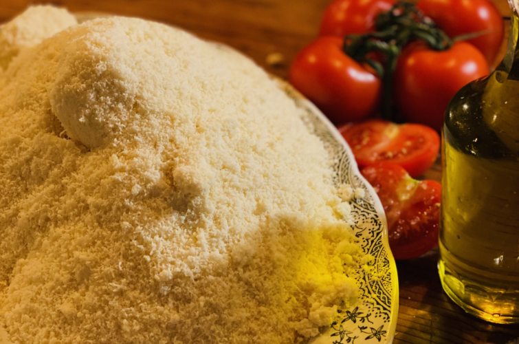 grana padano rapé dans une assiette, huile d'olive et tomates cerises